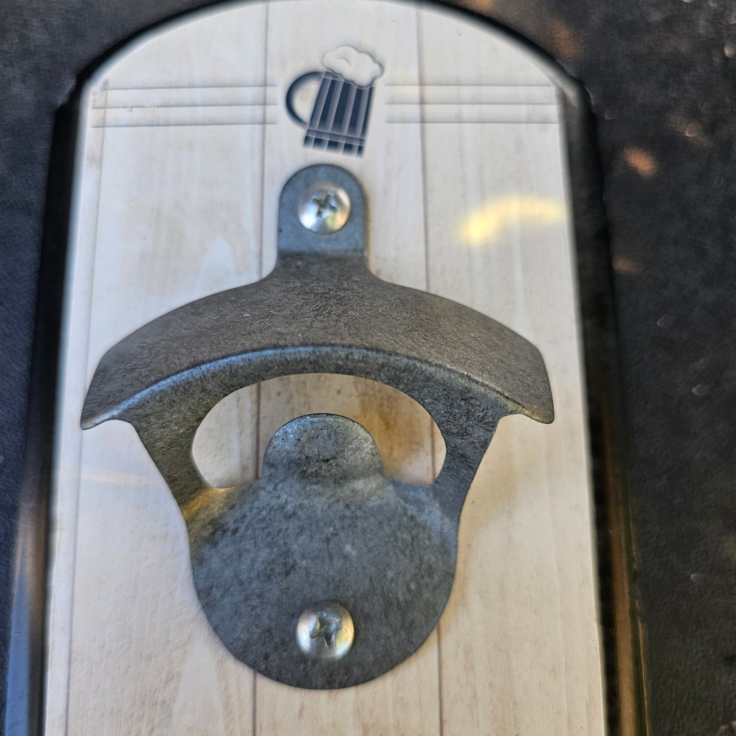 Wall-mounted bottle opener with a cap catcher