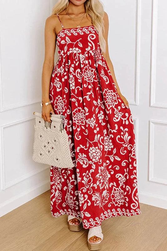 Red floral printed spaghetti strap empire waist maxi dress with white flower patterns and a flowing hemline