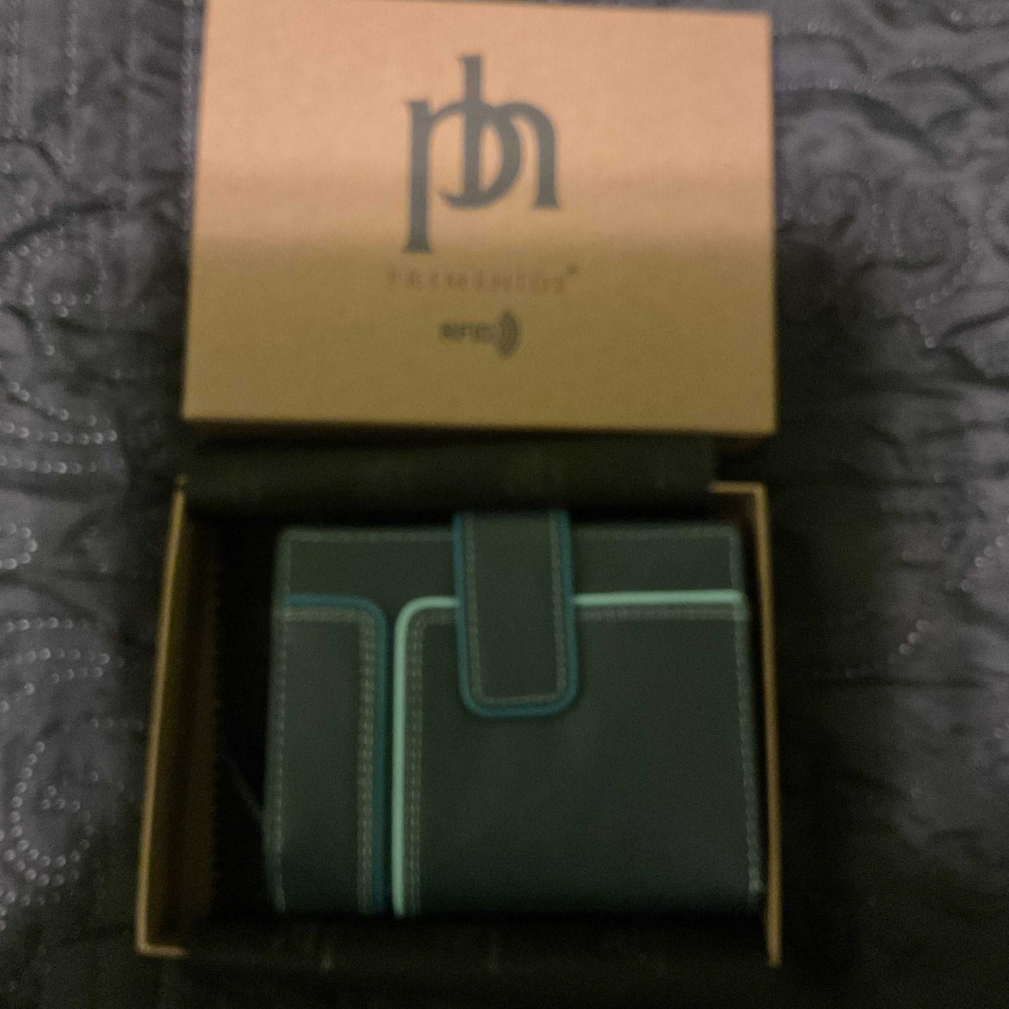 Prime hide women’s small RFID wallet in black with teal stitching in an open box