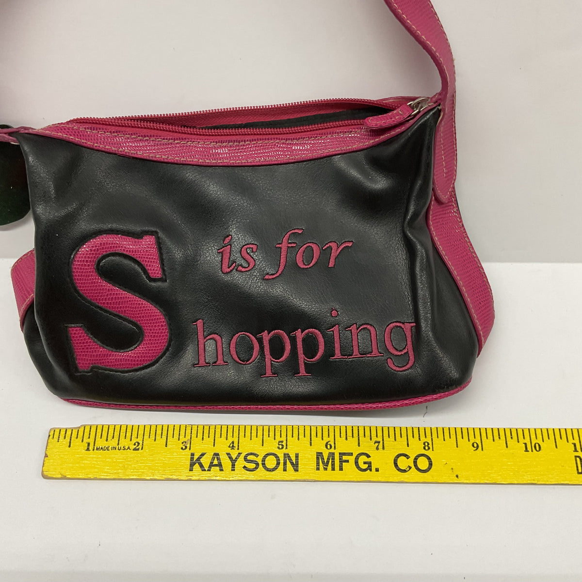 Garage Sale Unlimited black shoulder bag with pink trim and S is for Shopping graphic text and a paw print charm