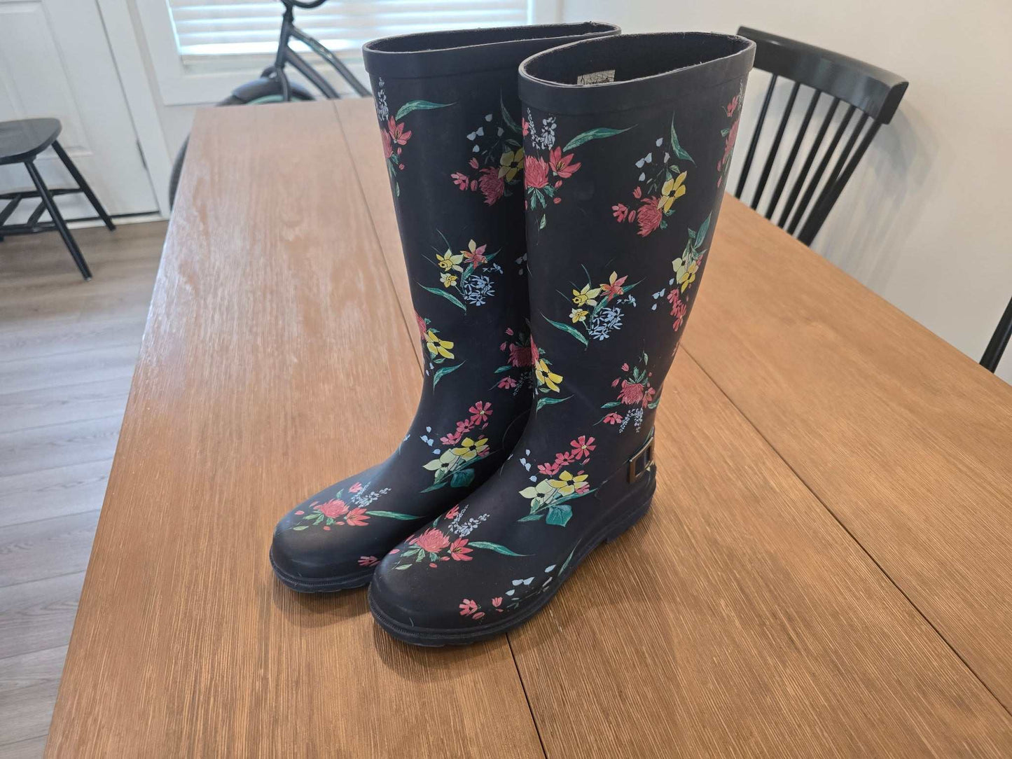 Size 8 floral pattern rain boots in good condition on wooden table